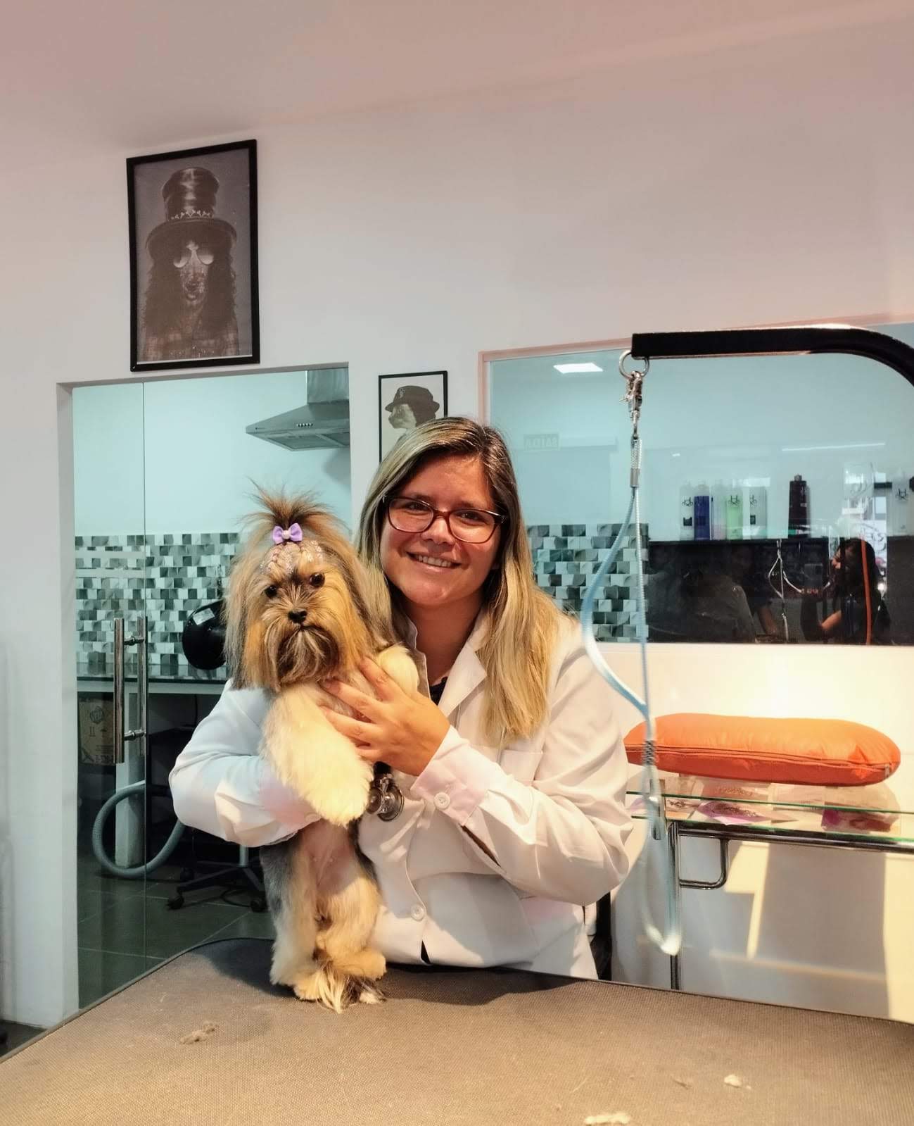 Dra. Quesia Klaus segurando um cão de pequeno porte durante consulta