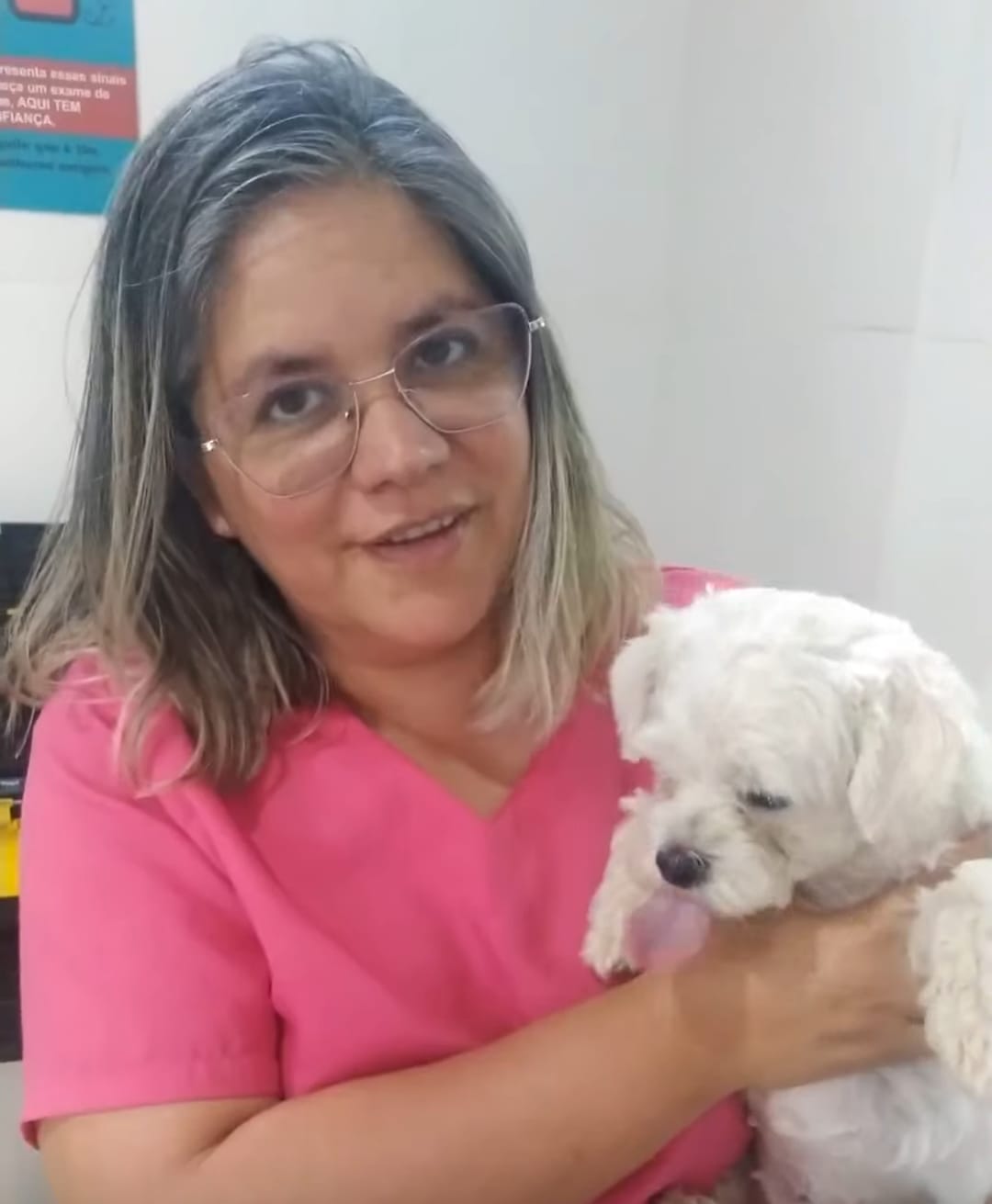 Dra. Quesia Klaus com um cão branco no colo
